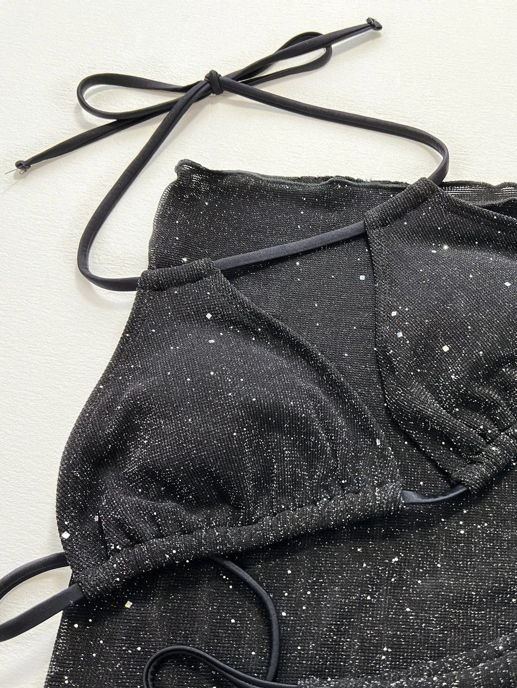 Black three-piece bikini swimsuit set with sports bra top and matching shorts