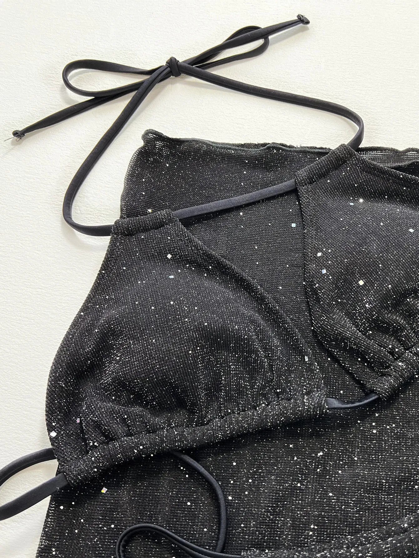 Black three-piece bikini swimsuit set with sports bra top and matching shorts