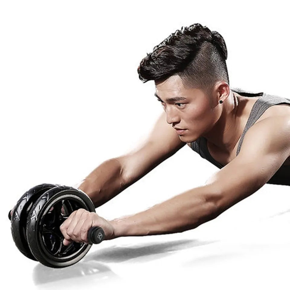 Black silent two-wheel abdominal roller with foam handles on a white background