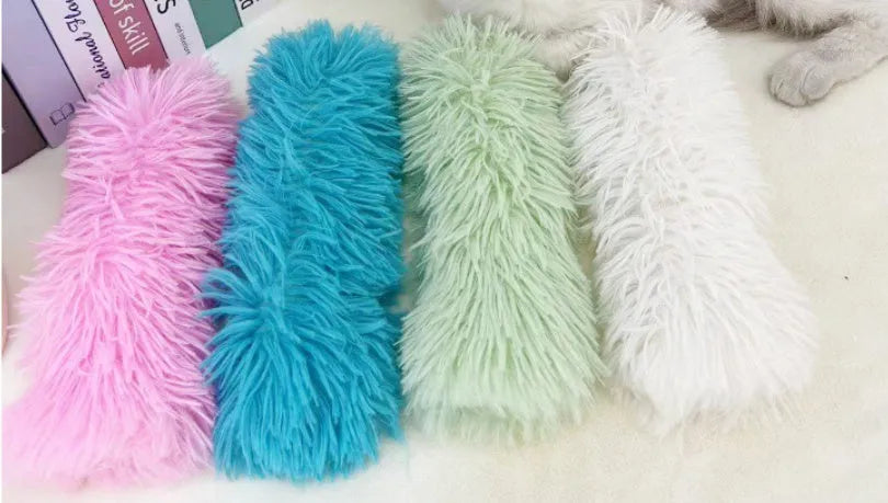 Soft plush cat toy pillow in blue, green, pink, and white colours measuring 27cm by 10cm