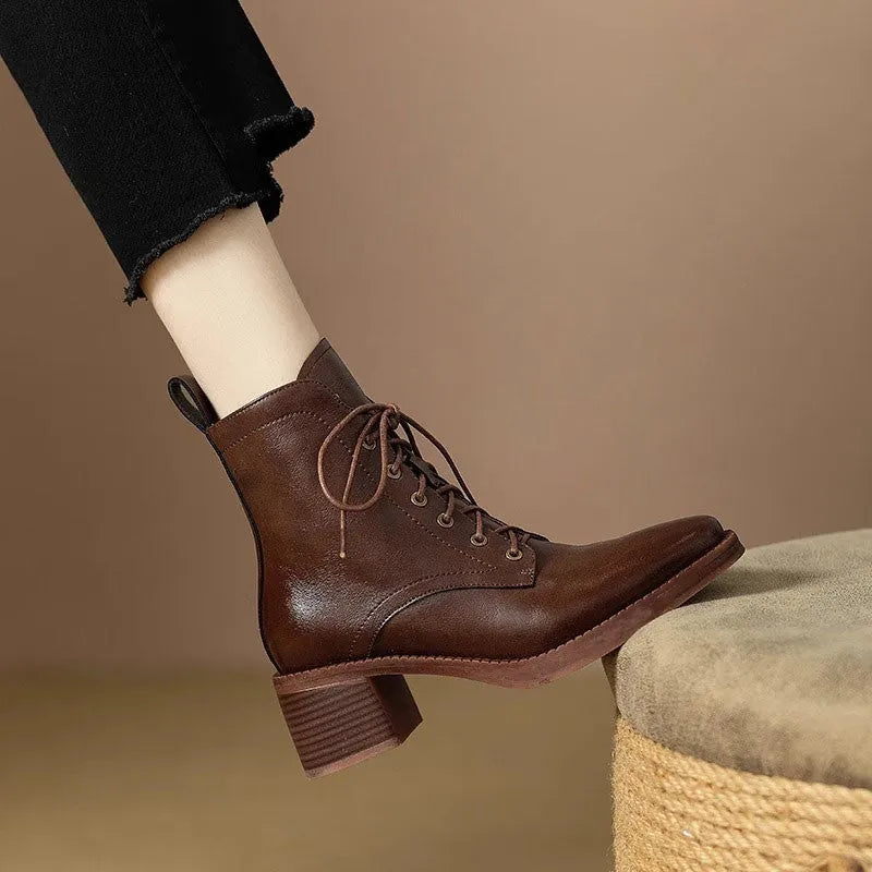 Women's black pointed-toe short tube ankle boots with a low block heel on a neutral background.