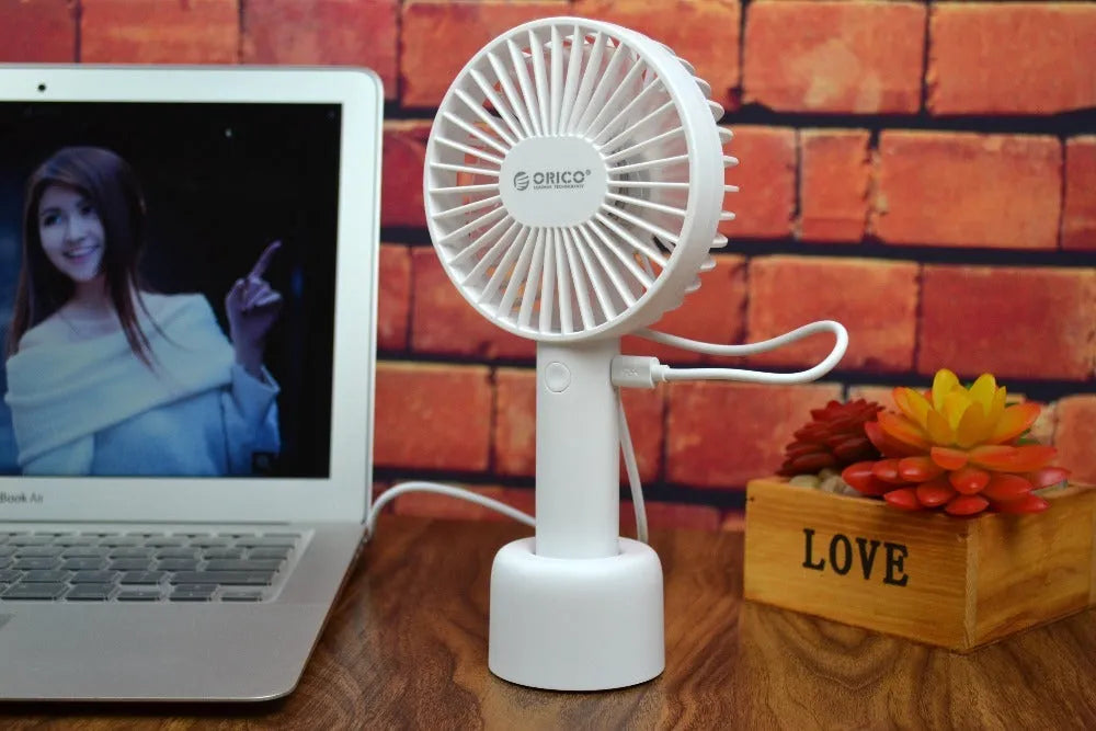 White ORICO FH1 USB rechargeable portable fan with fine-line texture on desk.
