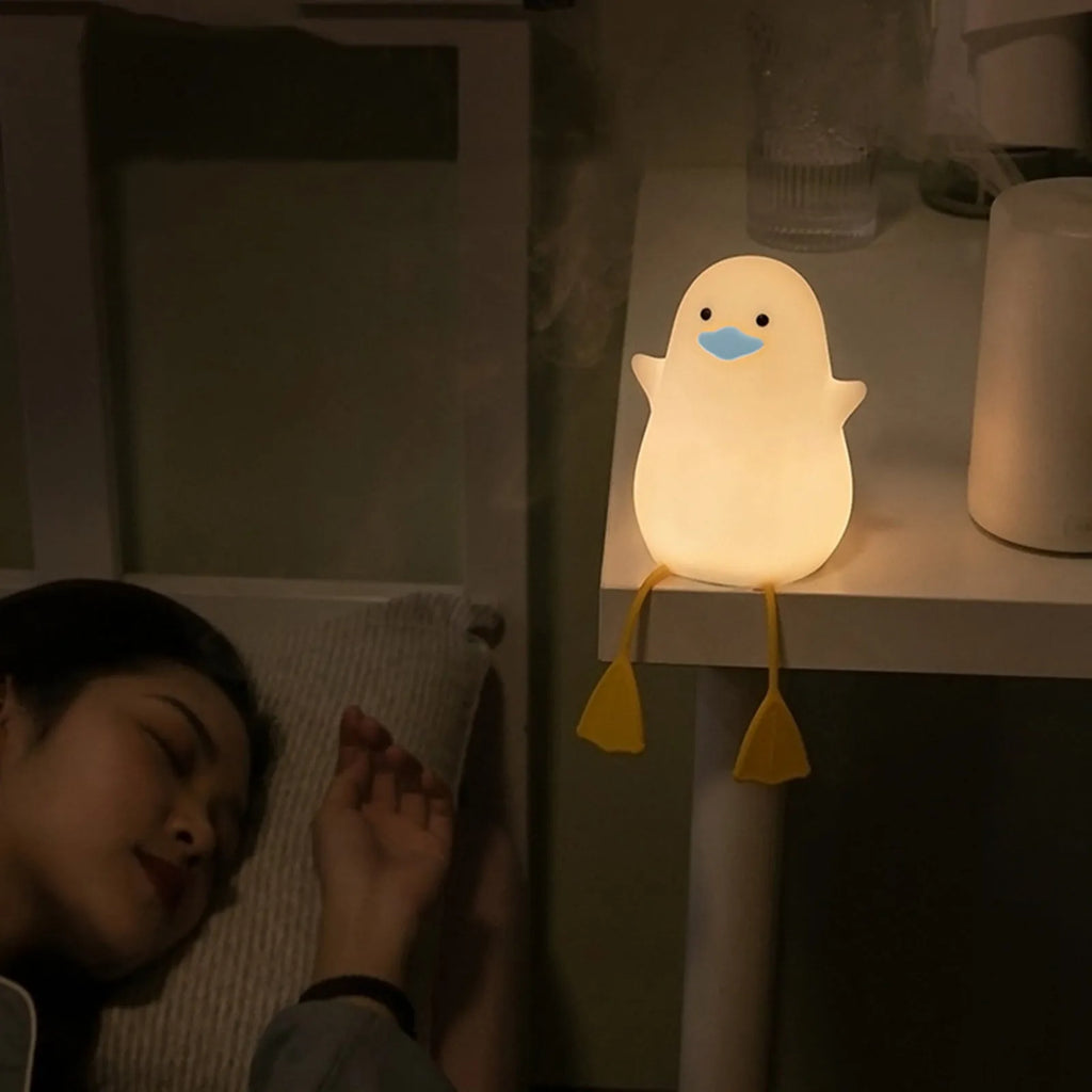 Seagull silicone night light in yellow colour with soft warm glow on bedside table