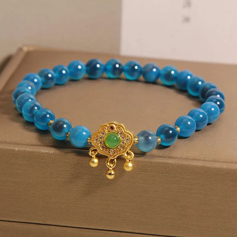 Blue agate safety lock pendant on a crystal women's bracelet with rhinestone details.
