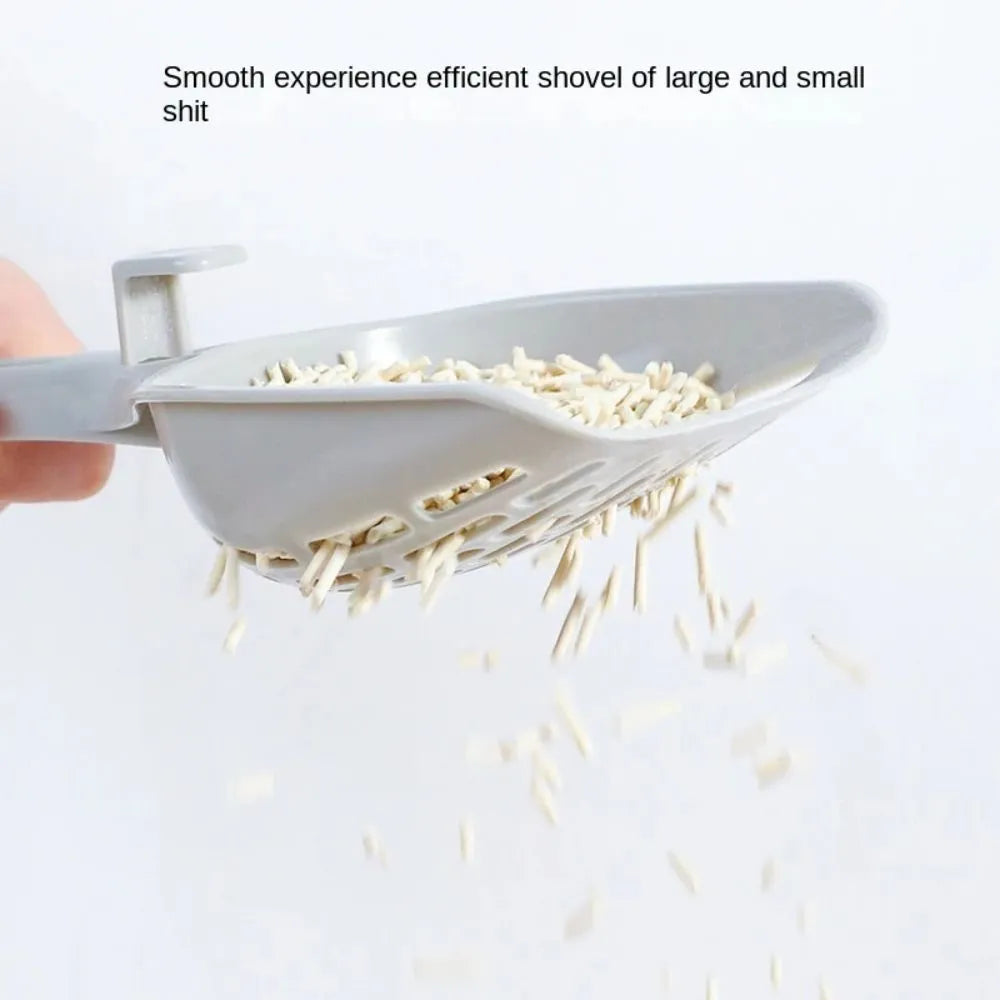 Grey plastic cat litter scoop with integrated base on a white background