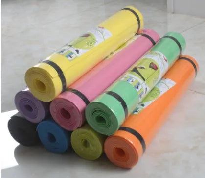 EVA foam yoga mat in blue, showing textured anti-slip surface, with a black OPP storage bag beside it.