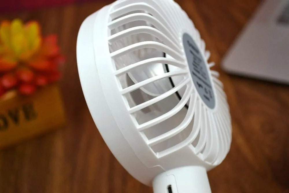 White ORICO FH1 USB rechargeable portable fan with fine-line texture on desk.