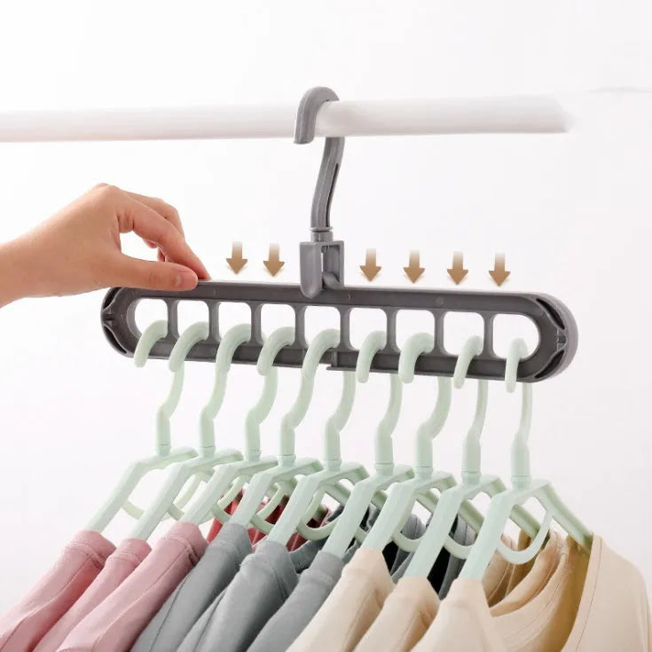 Plastic clothes hanger with rotating hook in pink and green colours on a rail.
