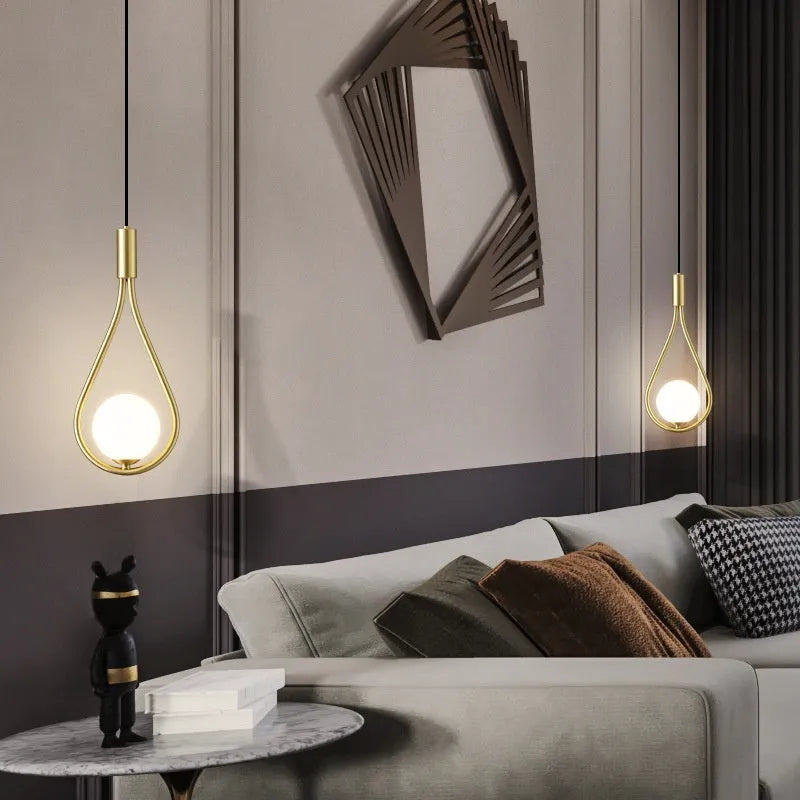 Modern copper bedside chandelier with adjustable hanging cord in minimalist bedroom setting