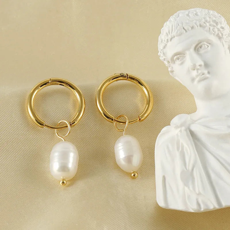 A pair of gold-coloured geometric stud earrings with a single pearl accent on each.