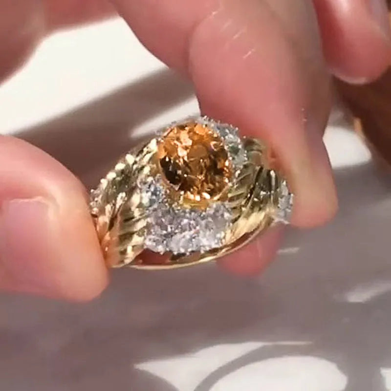 Gold-coloured copper women's ring with embossed feather design and inlaid yellow zircon stone.
