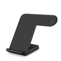 Black wireless phone charger on a desk next to a mobile phone, with a white Type-C cable.