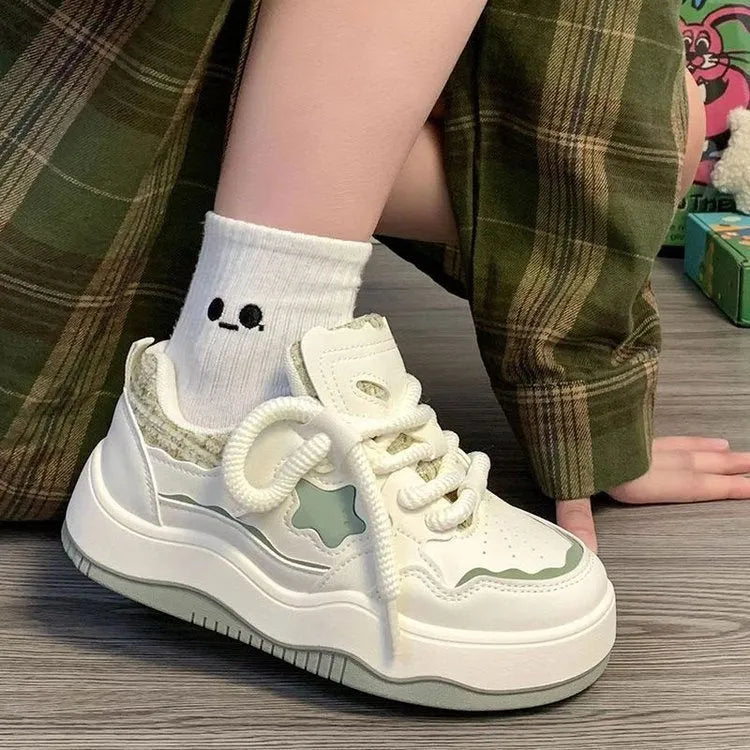 Women's green patent leather platform sneakers with round toe and lace-up front on a rubber sole.