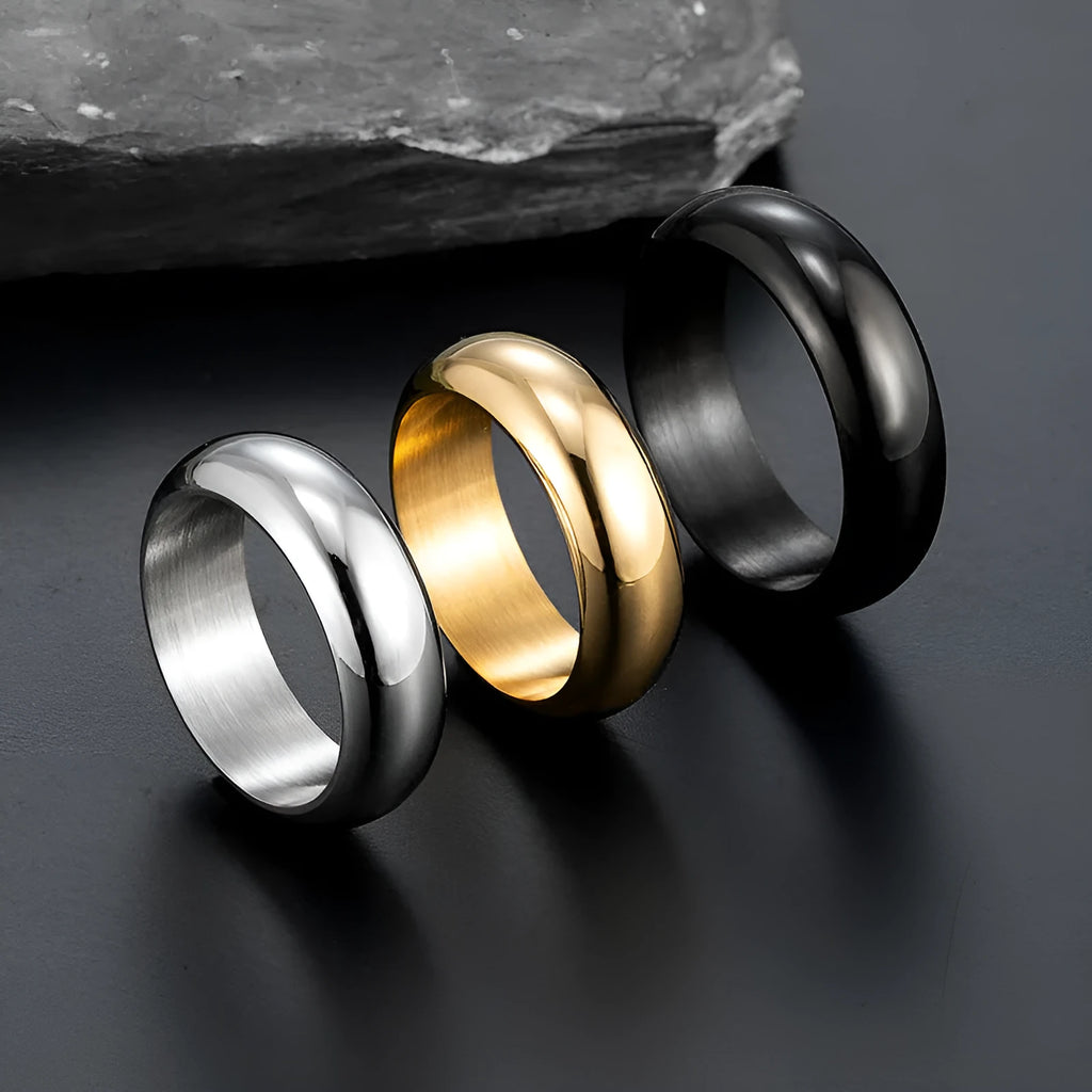 Glossy electroplated titanium steel ring in gold, black, and steel colours on a jewellery background.