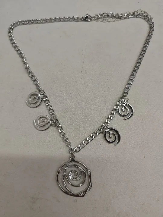 Gold spiral donut geometric jewellery set with adjustable necklace, matching bracelet, and earrings on a white background.