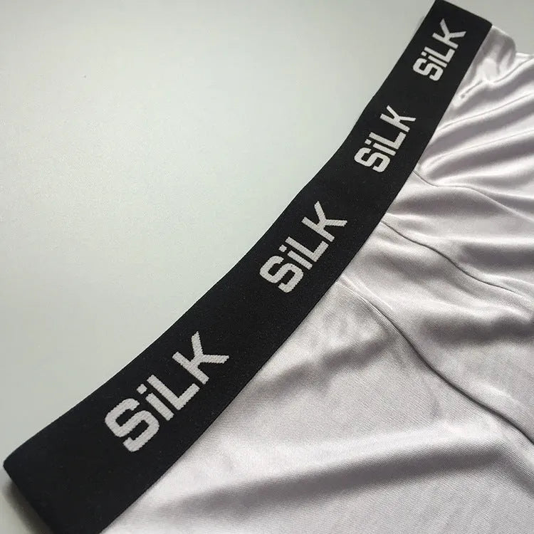 Men's loose-fit silk shorts in navy blue, shown laid flat.