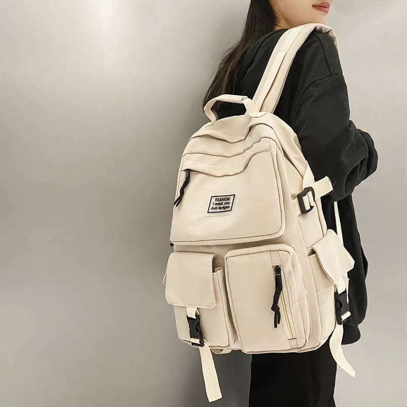 Black nylon student backpack showing front three-dimensional pocket and internal laptop compartment.