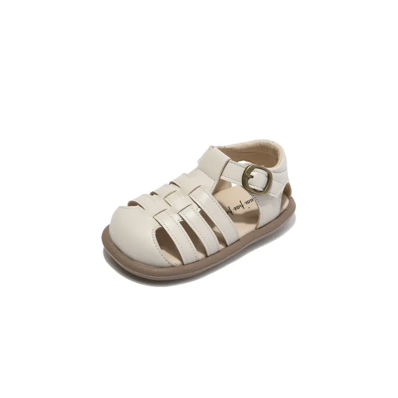 Girls' closed toe PU leather woven hollowed Roman sandals with Velcro strap, beige colour, on toddler feet