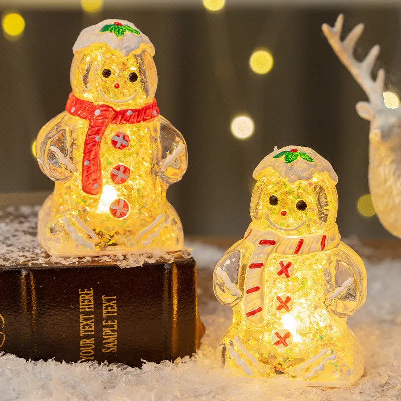 Glowing LED gingerbread man and snowman Christmas ornaments with coloured scarves on a festive tree branch.