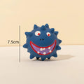 Four colourful natural latex squeaky dog toy balls with cute faces on a blue background.