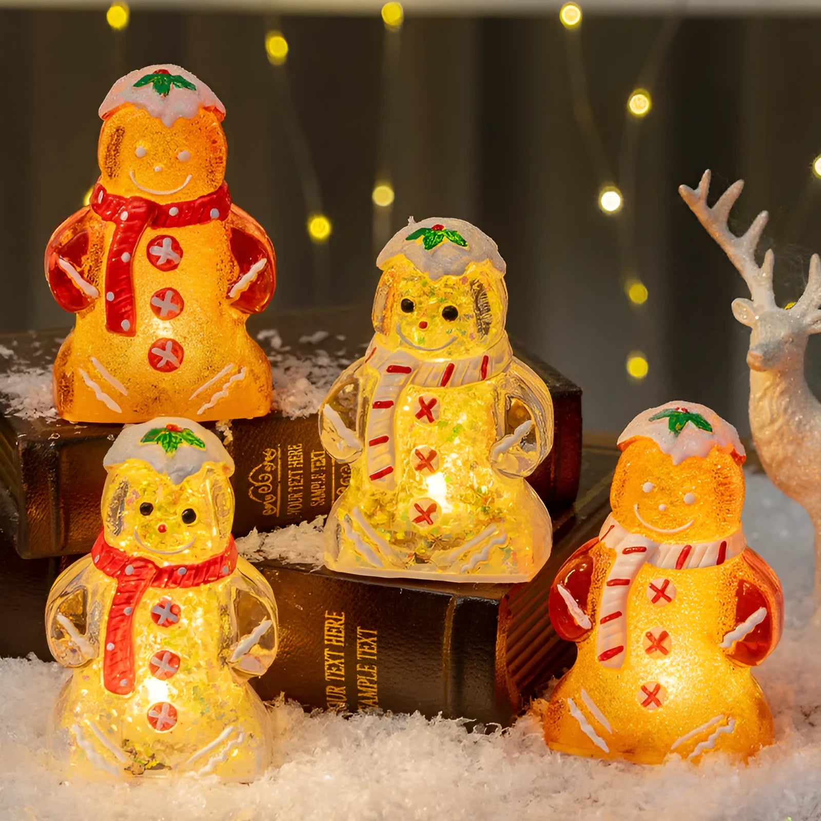 Glowing LED gingerbread man and snowman Christmas ornaments with coloured scarves on a festive tree branch.