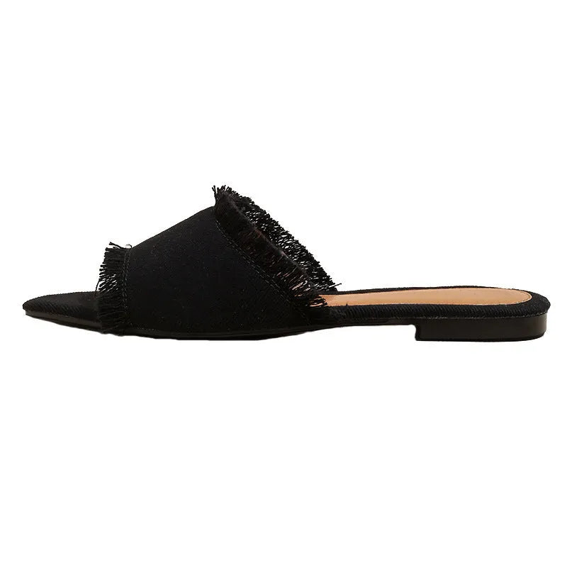 Women's denim flat slippers with tassel decoration and leather lining in apricot colour.