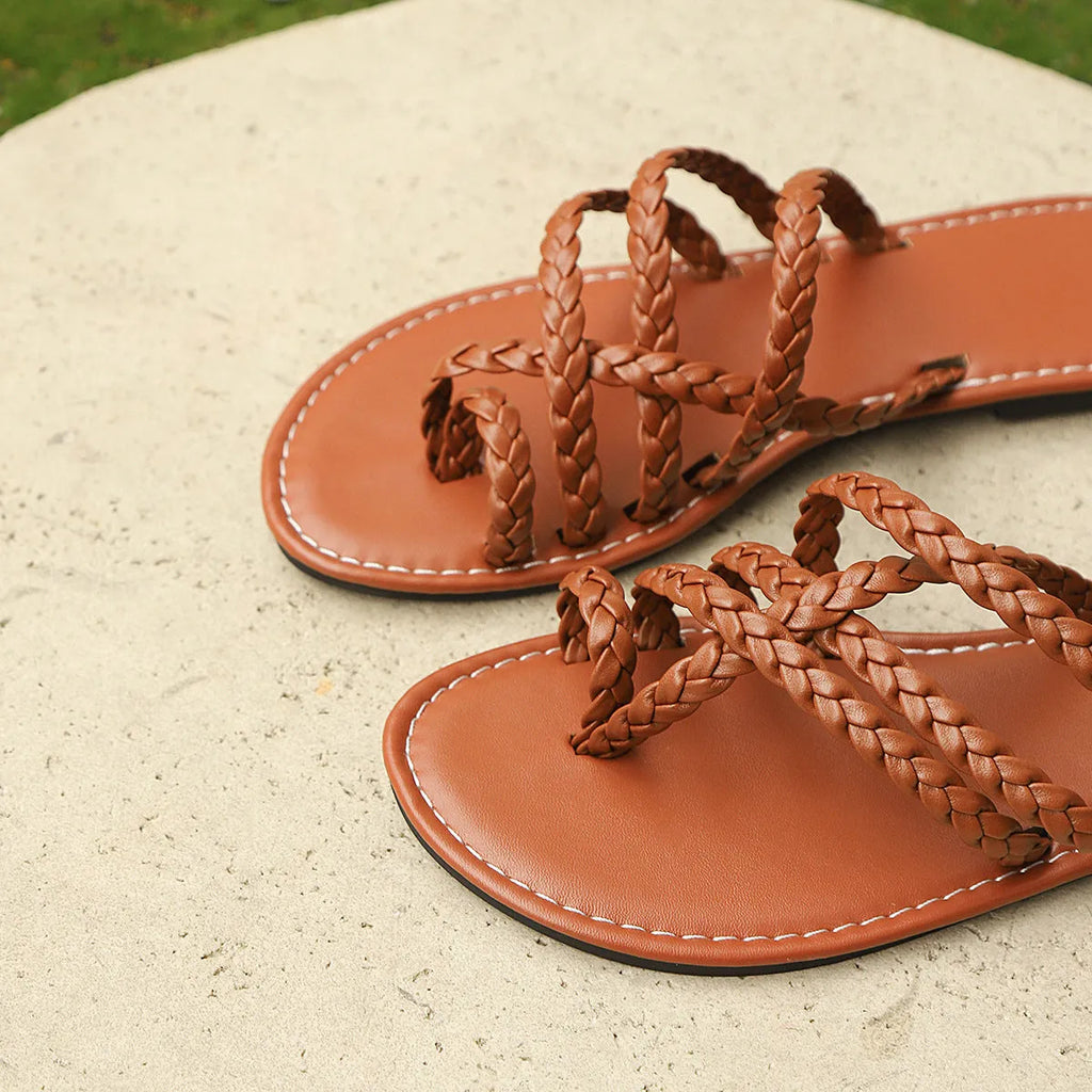 Women's black clip-toe woven flat sandals with a rubber sole on a neutral background.