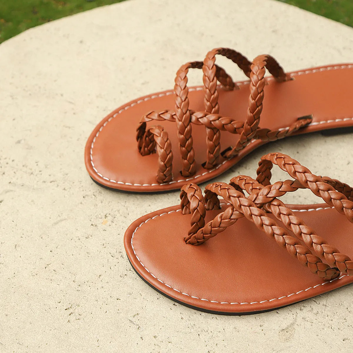 Women's black clip-toe woven flat sandals with a rubber sole on a neutral background.