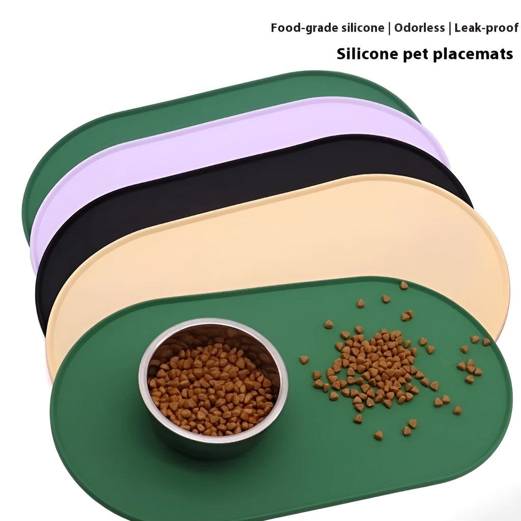 A green silicone placemat for cat food and water bowls on a wooden floor.