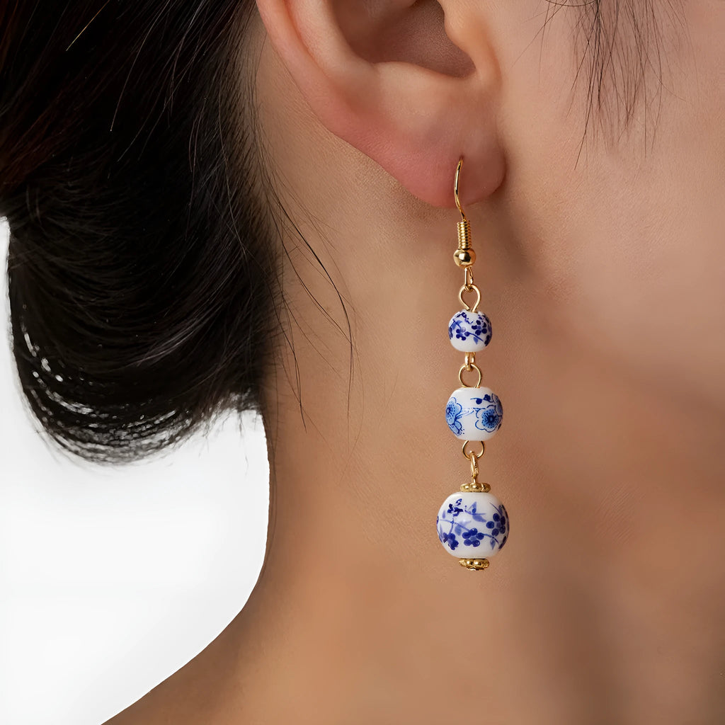 Long retro earrings with blue and white ceramic beads and geometric alloy parts.