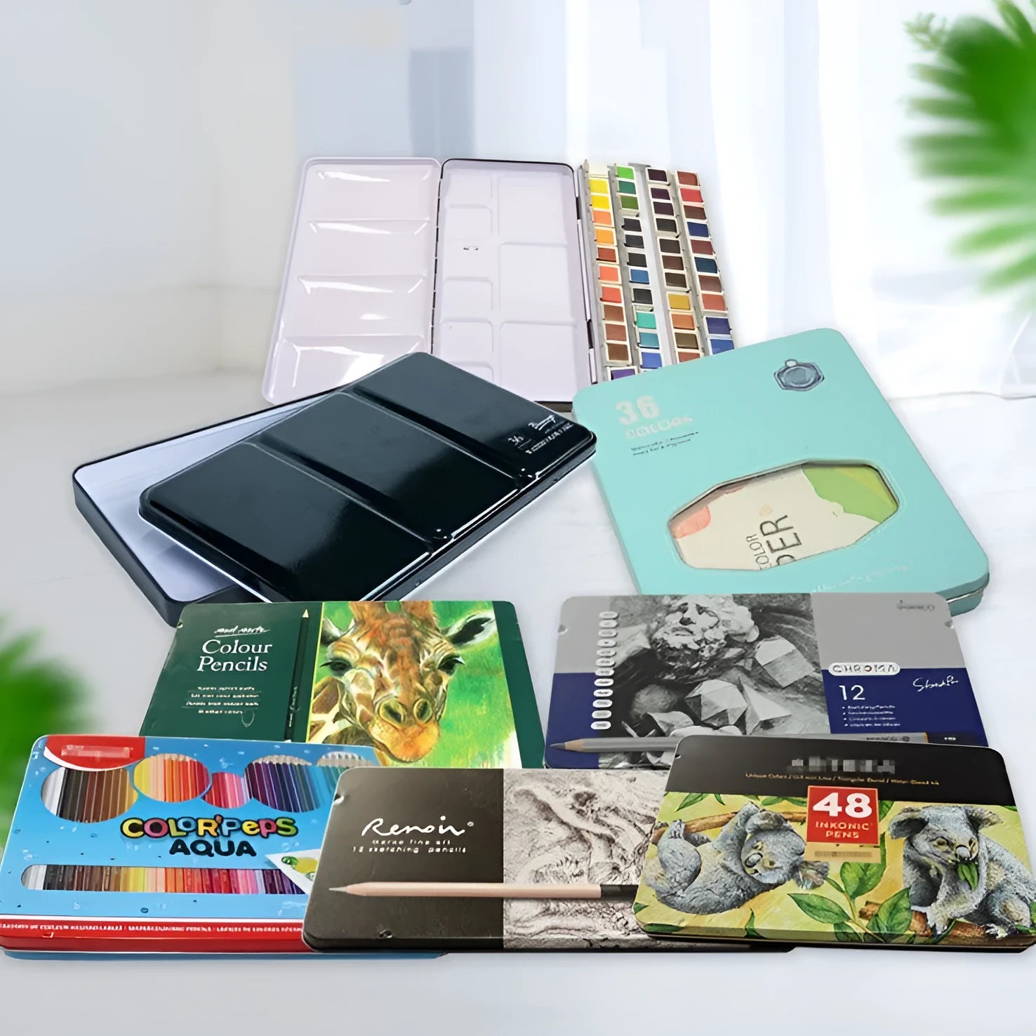 Tinplate metal folding watercolour paint box with colourful printed design, shown open to reveal compartments for solid paint pans.