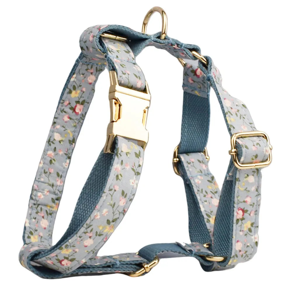 Blue floral pattern dog collar with matching leash, bow tie, vest and waste bag accessories on white background