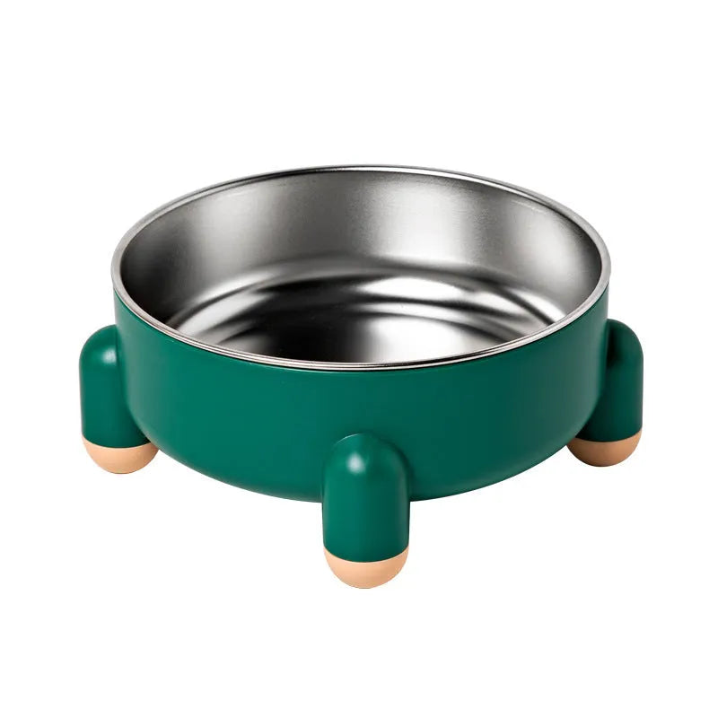 Green stainless steel pet bowl with a non-slip rubber ring and raised foot design on a wooden floor.
