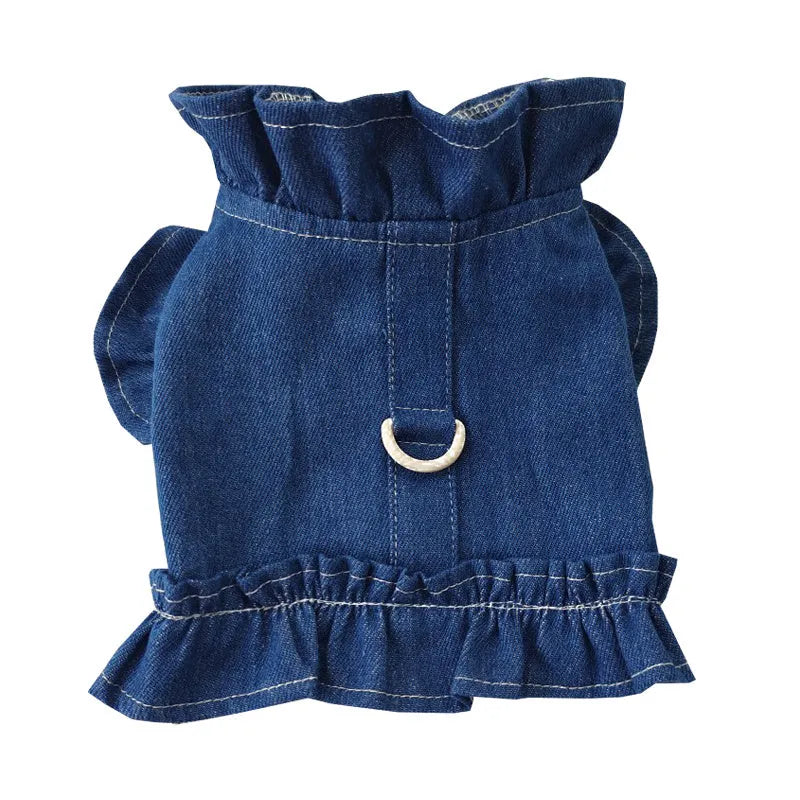 Blue denim dog dress with ruffles and built-in chest and back leash hooks on a small dog.