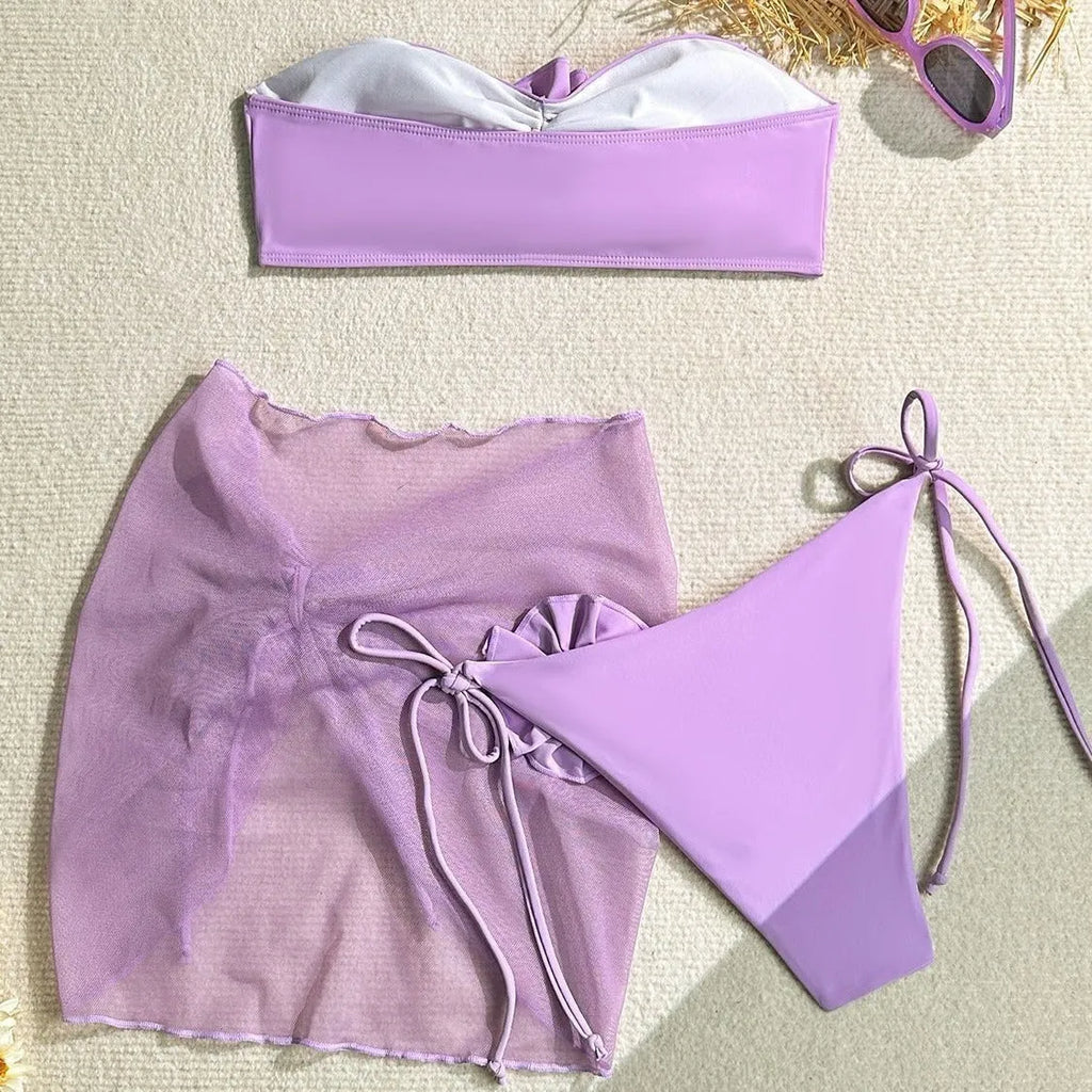 Women's pink tube top swimsuit with large flower tie, matching skirt and pants.