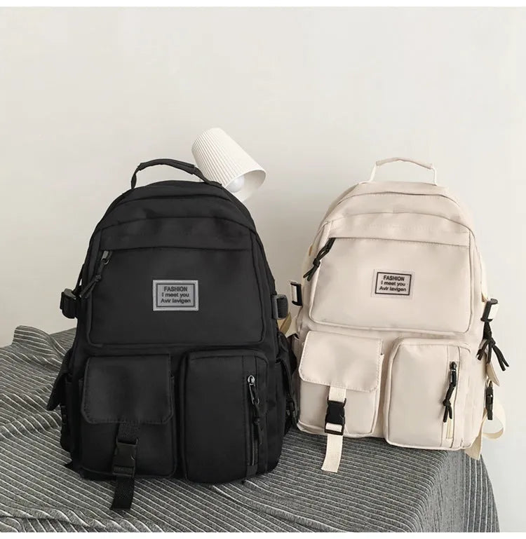 Black nylon student backpack showing front three-dimensional pocket and internal laptop compartment.