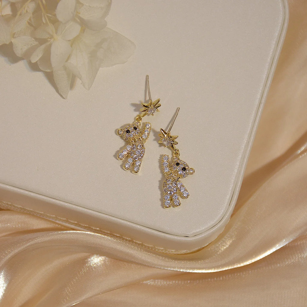 Star-shaped stud earrings in gold with diamond-cut metal and inlaid artificial stones