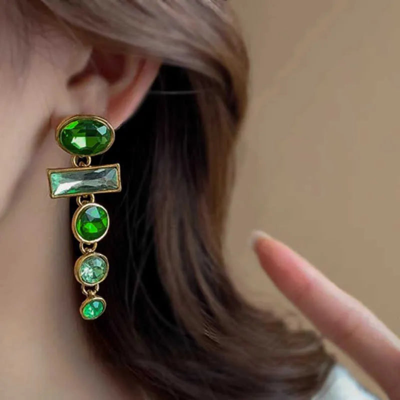 A pair of green gradient alloy earrings with geometric shapes, inlaid zircon stones, and decorative tassels.