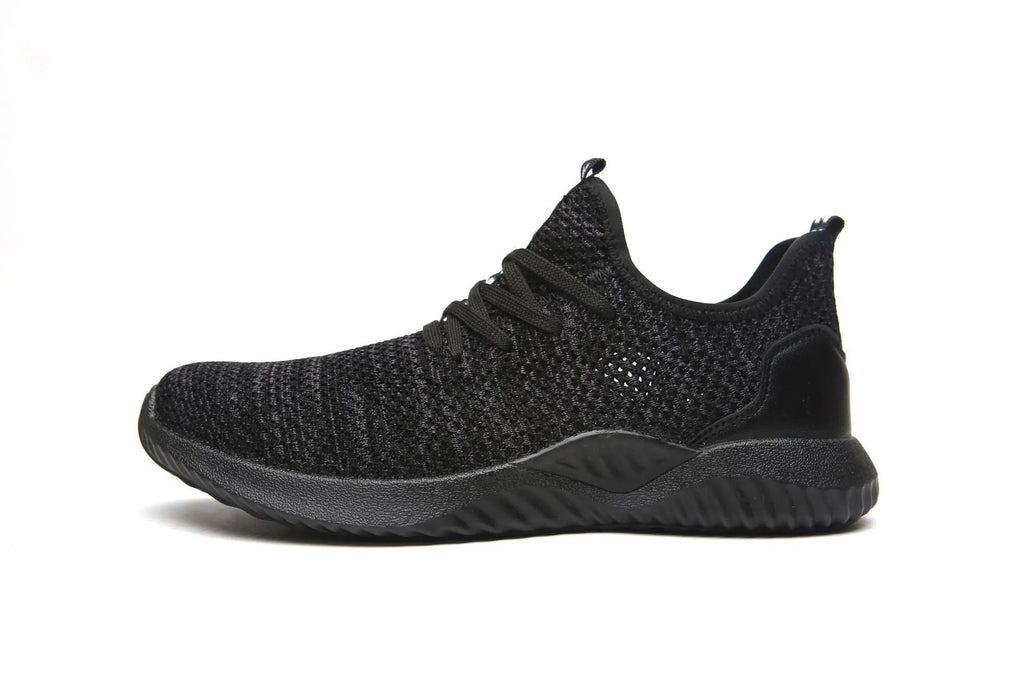 Steel toe cap safety work shoes in black with low-cut design, shown on a work site background.