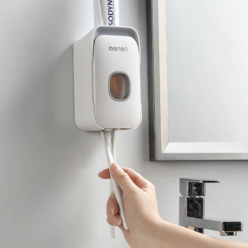Automatic wall-mounted toothpaste dispenser in blue colour on a bathroom wall.