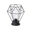 Hollow wrought iron wine bottle shaped table lamp with warm white LED light on a wooden desk