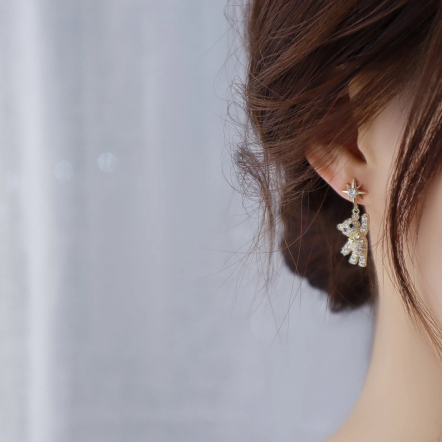 Star-shaped stud earrings in gold with diamond-cut metal and inlaid artificial stones