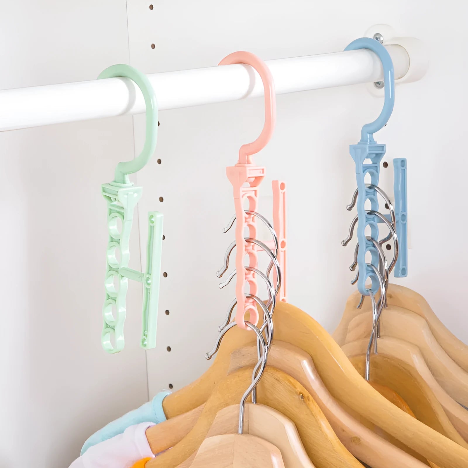 Magic revolving wardrobe hanger with five holes and handle in blue, green, or pink for clothes organisation