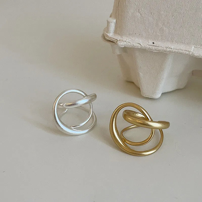 Three-dimensional interlaced geometric open ring in matte metal with gold electroplating