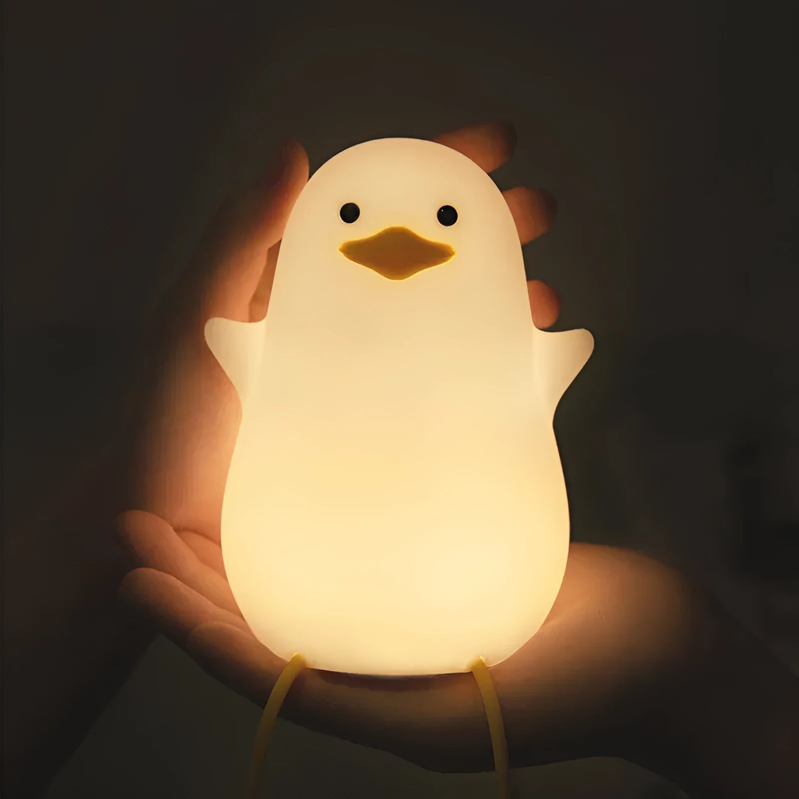 Seagull silicone night light in yellow colour with soft warm glow on bedside table