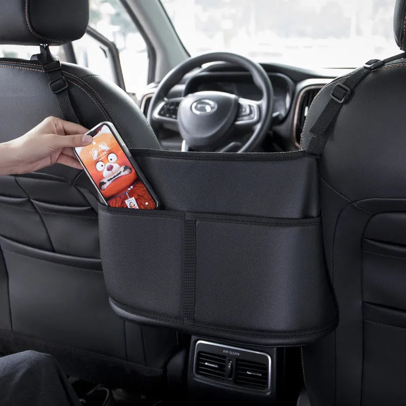 Genuine leather car seat storage bag with carbon fibre pattern, shown installed in a middle seat net pocket.