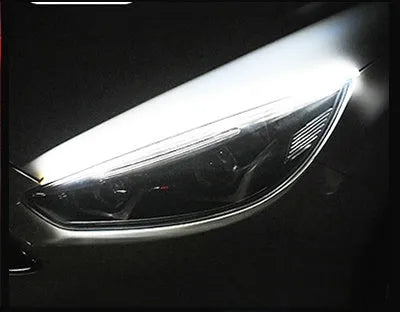Slim silicone car LED daytime running light strip with flowing turn signal effect on a vehicle headlight.