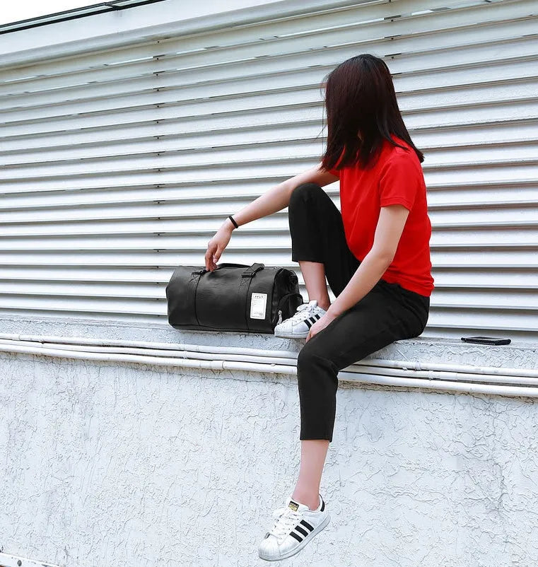 Black waterproof sports bag with separate side compartments for shoes, shown with diagonal carrying strap.