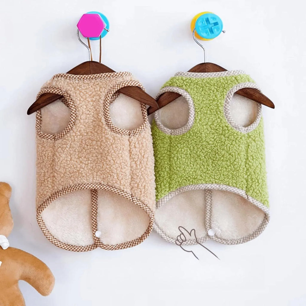 Green coral fleece dog vest with a metal leash ring on the back, fastened at the side on a small dog.