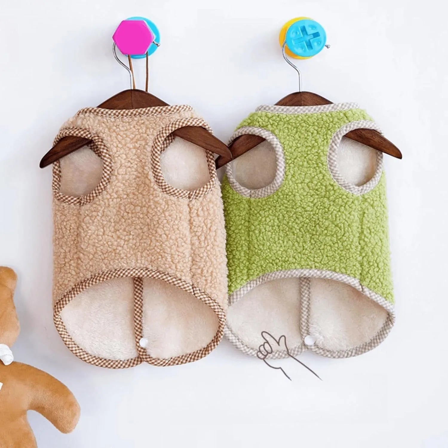 Green coral fleece dog vest with a metal leash ring on the back, fastened at the side on a small dog.